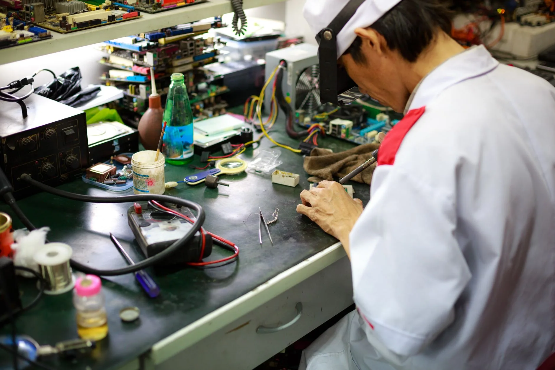 Teknisi servis iPhone di meja kerja bengkel Teknisi servis iPhone di meja kerja bengkel